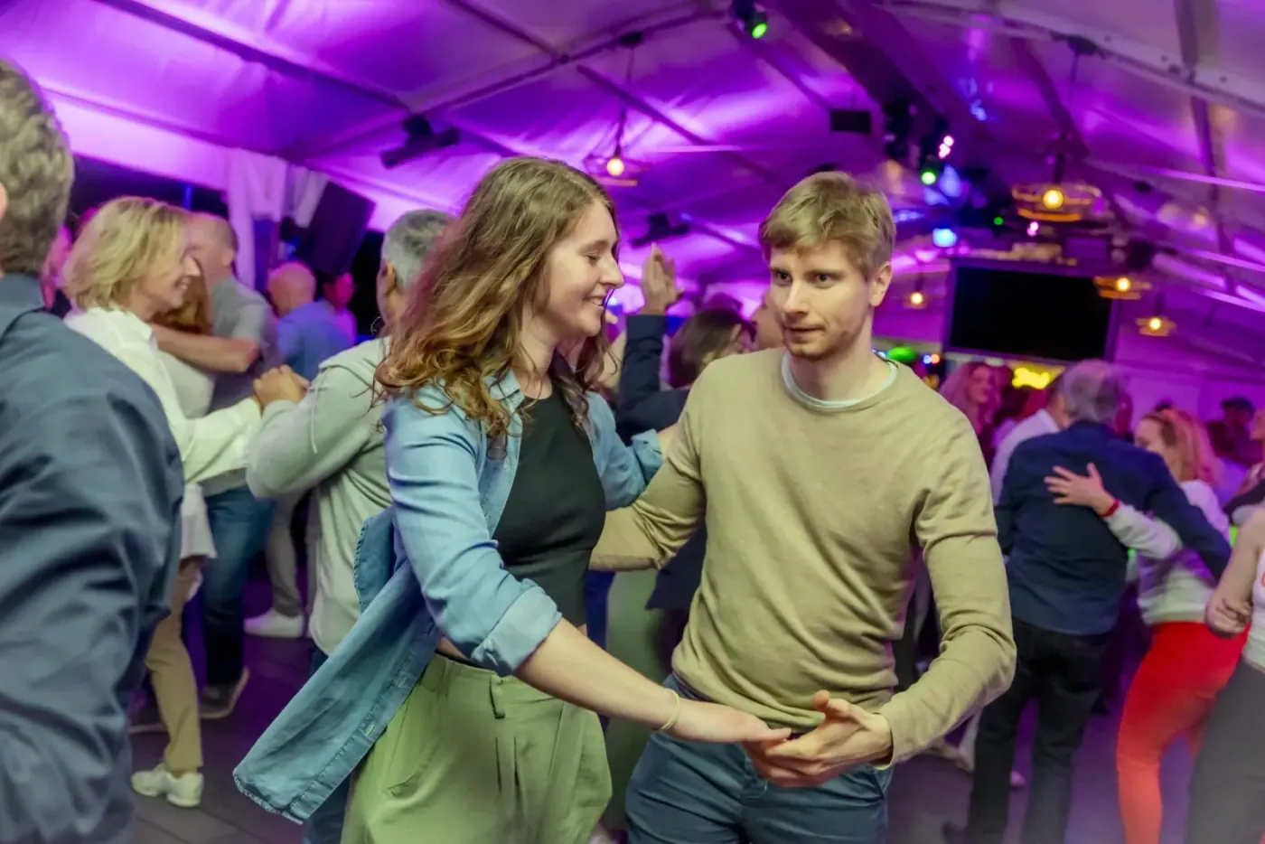 Couples social dancing under purple light at Salsa House in Vienna